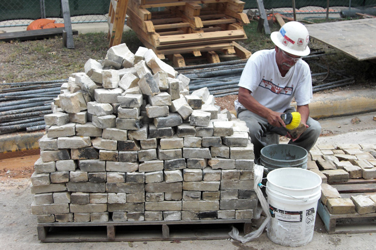 A Worker Cleans Historic Bricks for Reuse
